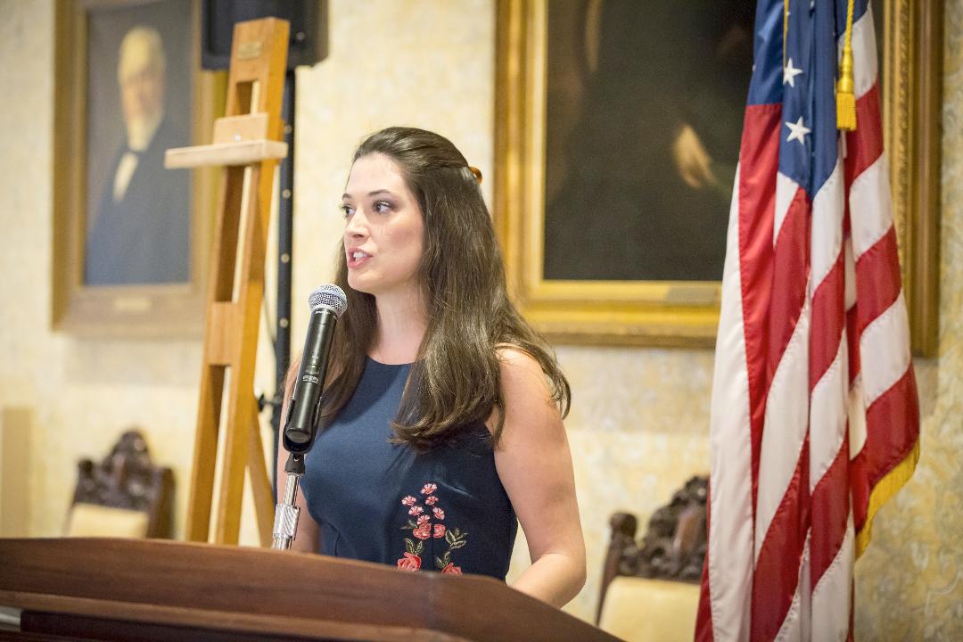 Kelly Morgan speaking at a lectern.