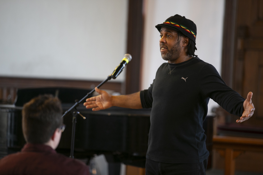 Victor Wooten standing with his arms outstretched