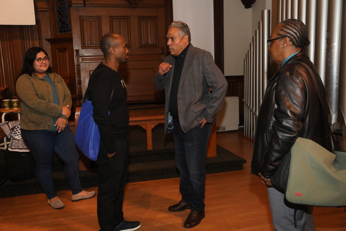 Eduardo Bonilla-Silva talks to an attendee while two others look on