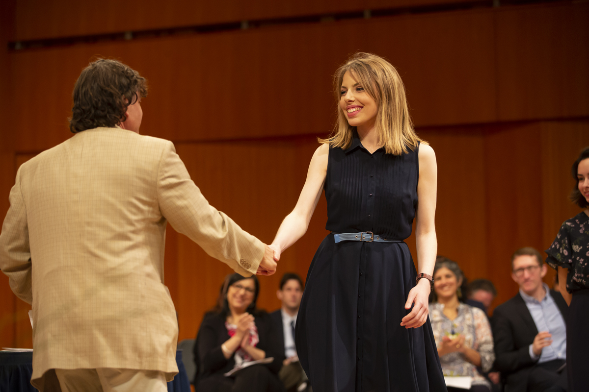 Assistant Professor Jonathan Golden shakes hands with Shayna Miller