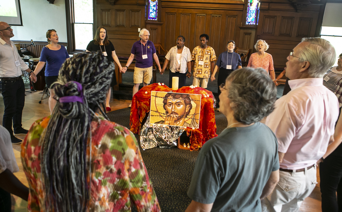 Group stands in a circle holding hands inside Craig Chapel